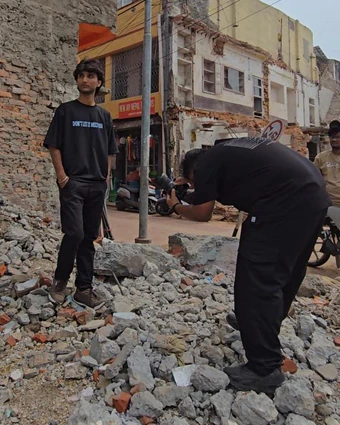 A model standing on rubble while our photographer shoots him from below