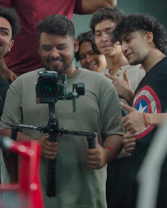 The crew smiling around a camera on a gimbal