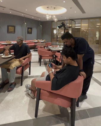 Restaurant shoot: people checking a phone next to a camera on a tripod