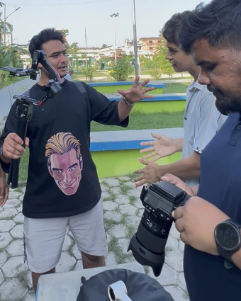Briefing the shot with a gimbal in a pop-art T-shirt while another crew member holds a camera